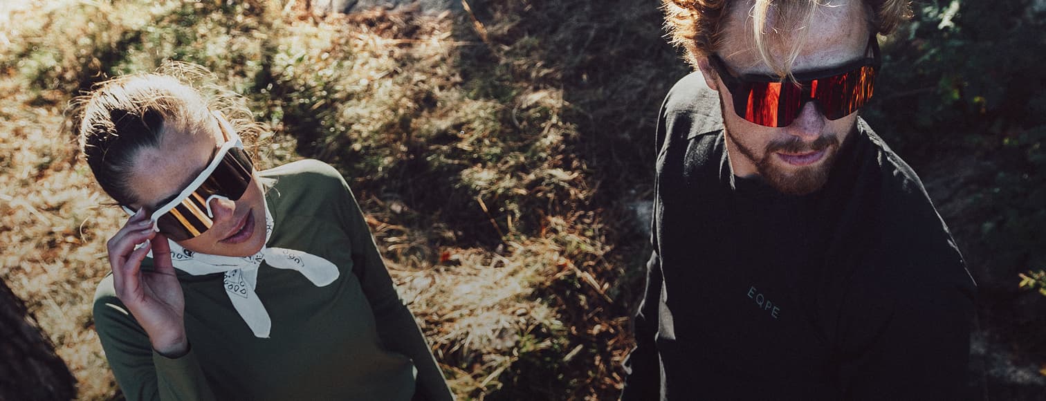 Two people wearing sporty sunglasses and running gear.