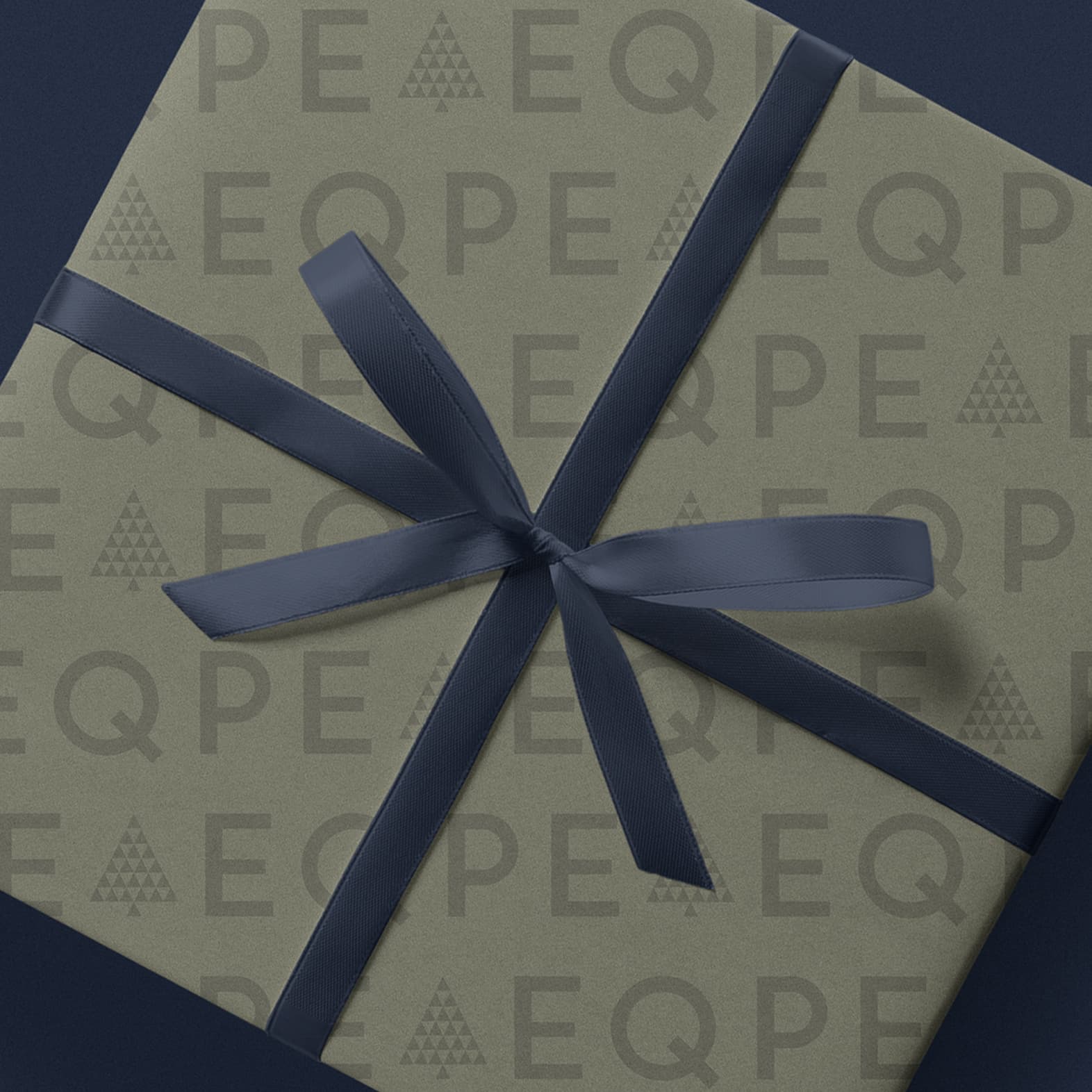 Gift box wrapped in patterned paper with "EQPE" and triangle designs, tied with a dark blue ribbon, on a dark blue background.